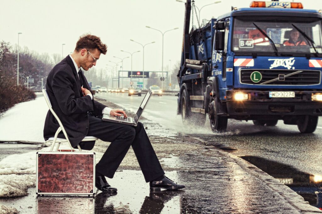 Man waiting for a train to go to work while on his laptop