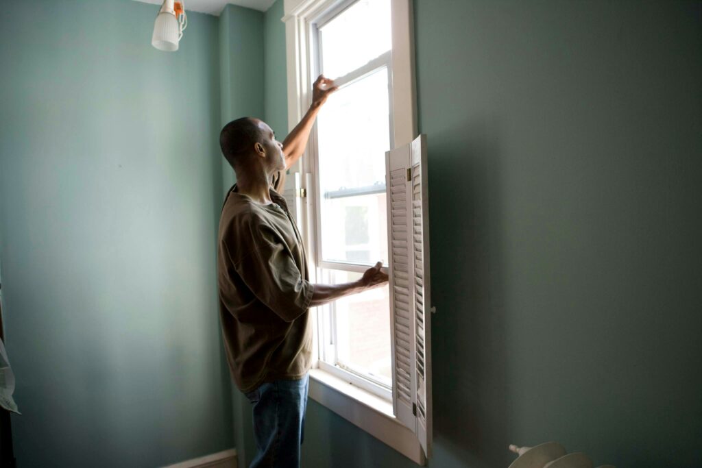 Man opening his windows in his home to manage environmental toxins