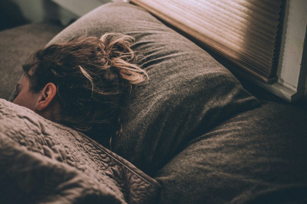 Woman asleep in her bed with head on pillow